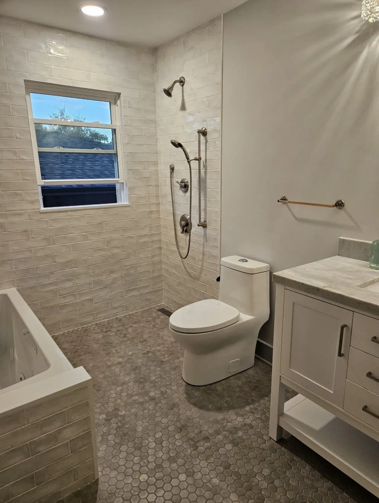 Bathroom remodel with tile floor and white vanity