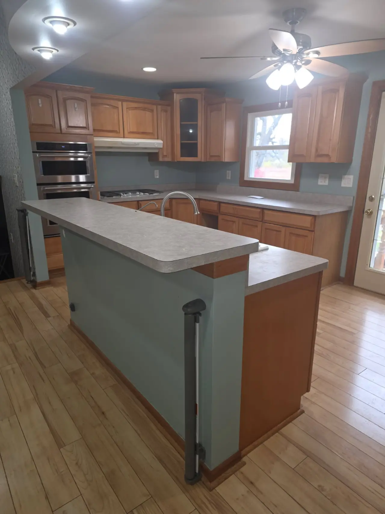 Before: Honey oak peninsula to an open kitchen with a navy island